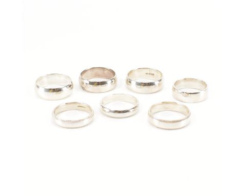 A collection of eight silver wedding band rings. The ring in band form some wide some having border decoration. Widths approx