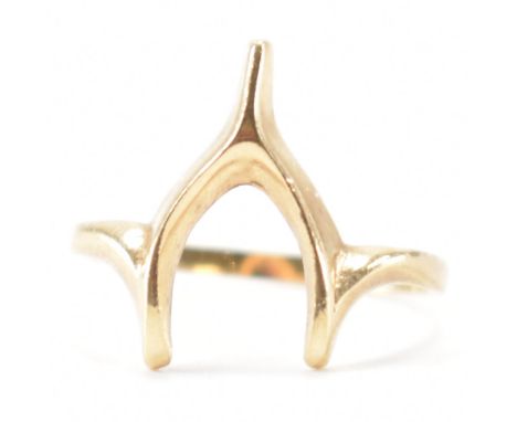 A hallmarked 9ct yellow gold wishbone ring. The ring having a knife edged wish bone head to a plain shank. Hallmarked for Lon