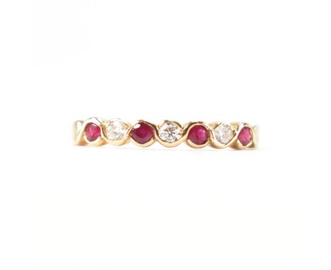 A hallmarked 9ct gold ruby and diamond half eternity ring. The ring set with four round mixed cut ruby having three round bri