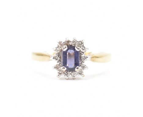 A hallmarked 9ct gold iolite and diamond cluster ring. The ring set with a central rectangular step cut iolite framed by a ha