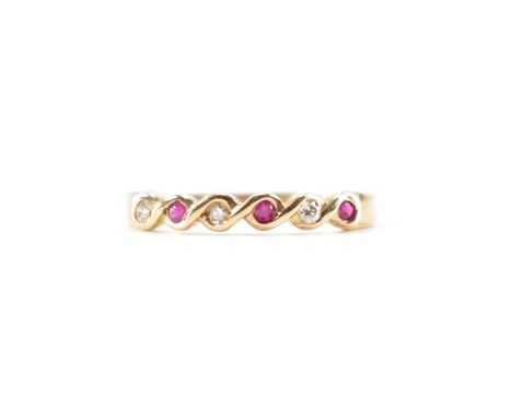 A hallmarked 9ct gold ruby and diamond half eternity ring. The ring set with three round mixed cut ruby having three round br