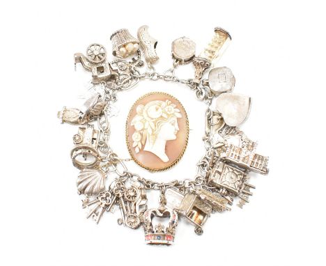 A silver and white metal charm bracelet together with a yellow metal cameo brooch pin. The bracelet strung with various white