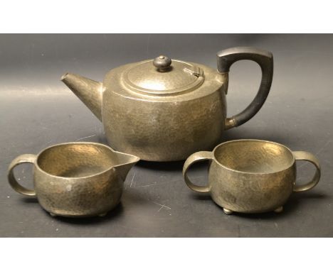 A Trudric pewter three piece tea service, for Libertys, planished ground, serial number 01536, stamped, ninetieth century. 