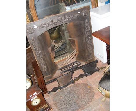 A metal fire surround and grate in three pieces and a partial iron fire back 