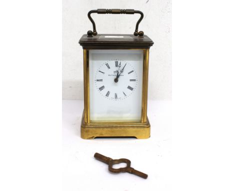 A Matthew Norman brass cased carriage clock, with presentation plaque to reverse, carry handle to top and glazed door showing