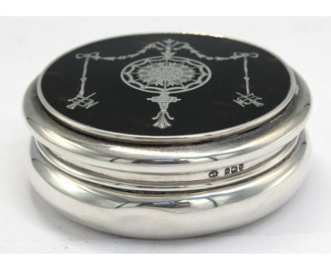 An Edwardian circular silver and faux tortoiseshell trinket box, having silver inlayed neo-classical style decoration, cushio