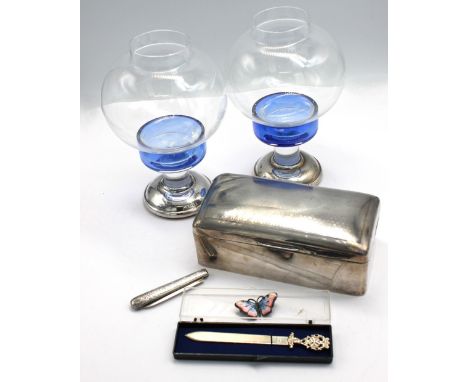 A collection of silver items to include; a pair of Modern silver table candle-lamps, having blue glass bowls with removable c