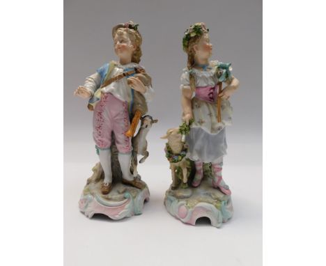 A pair of Continental figures of a boy and girl. The boy with a set of bagpipes under his left arm and a goat at his side and