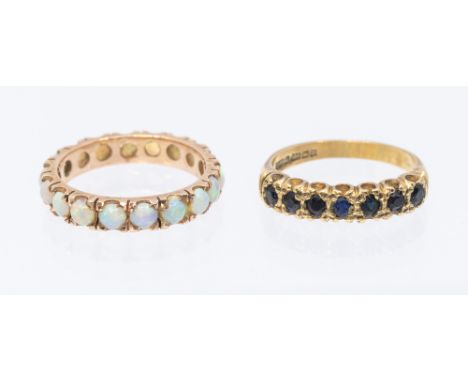 An opal and rose metal eternity ring, width approx 4mm, size N1/2, unmarked assessed as 9ct gold, along with a seven stone sa