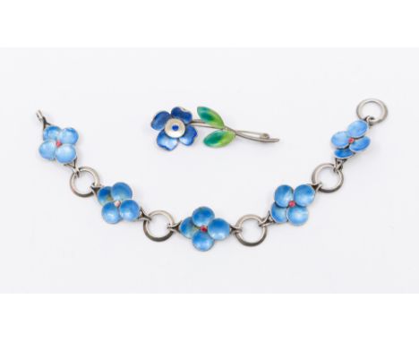 A 20th century silver and enamel floral bracelet, having five four petalled blue flowers with red centres, on ring chains, on