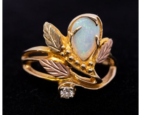 An opal and diamond 10ct gold, comprising a pear shaped opal approx 8x5mm, within a three colour mount decorated with leaf mo