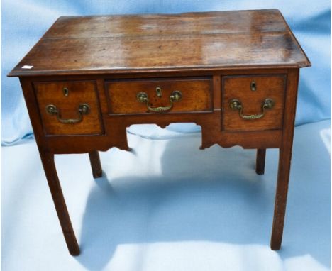 An early 18th Century George I lowboy with three front frieze drawers, ornate apron, standing on block legs, in oak along wit