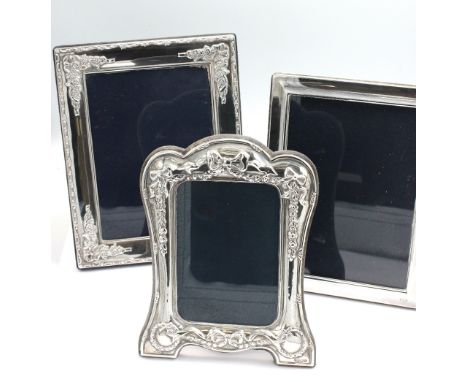 A collection of three Modern silver photo frames to include; an elaborate frame with cast bows and foliate decoration, hallma