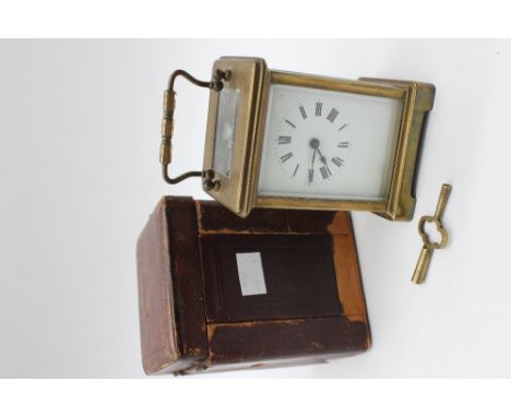 A late 19th Century 8 day French brass carriage clock with white enamelled face, Roman numerals, glazed with bevelled glass a