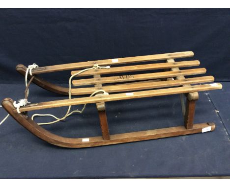 A mid 20th Century wooden child's sledge with Davos written on the top rails.