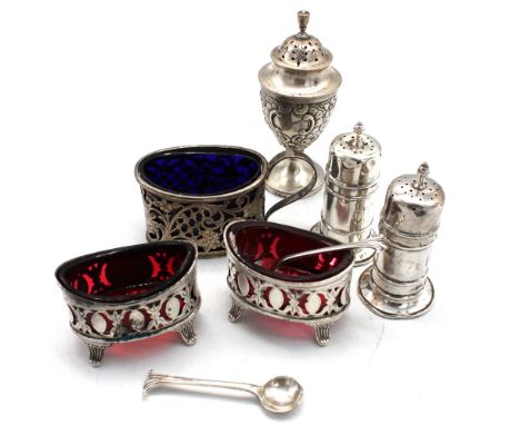 A small collection of silver condiment items to include; a George V silver oval shaped one handled salt cellar, with pierced 