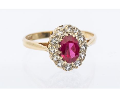 A ruby and diamond set 9ct gold ring, comprising an oval mixed to the centre approx.3x6mm, within a border of small diamonds,