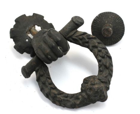 A Georgian painted cast iron door knocker in the form of a clenched fist and lion mask and laurel