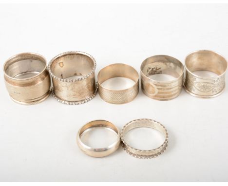 Seven hallmarked silver napkin rings, engine turned, plain and engraved varying from 9mm to 30m wide, total weight approximat