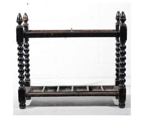 Dark oak stick stand, bobbin turned uprights, width 78cm.