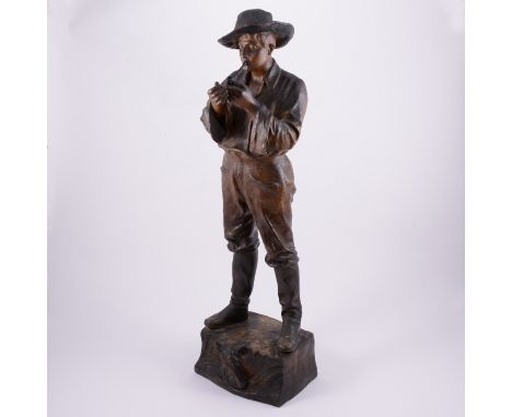 Cherc for Goldscheider, 'Gaucho' a patinated terracotta figure, circa 1900, modelled as a cowboy lighting a pipe, raised on a