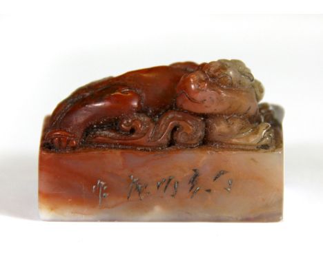 A Chinese caved soapstone seal mounted with a dragon, H. 4cm.