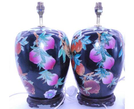 A pair of modern ceramic table lamps by Roche Bobois, each of baluster form, decorated with fruit and heightened in gilt on a