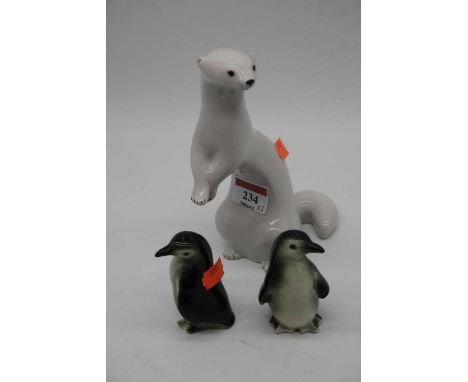 A Russian Lomonosov porcelain model of a ferret, h.18cm; together with a pair of Goebel novelty cruets in the form of penguin