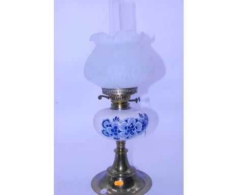 A 20th century oil lamp having an opalescent glass shade with blue &amp; white ceramic font, decorated with flowers on a bras
