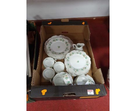 An early 20th century part tea service, on a white ground with green and brown floral decoration within gilt border, having p