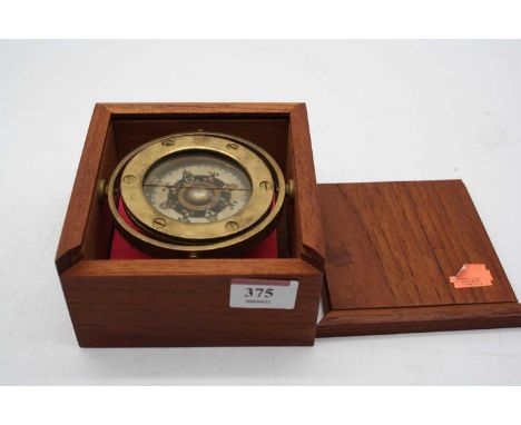 A lacquered brass ships compass housed in a teak case 