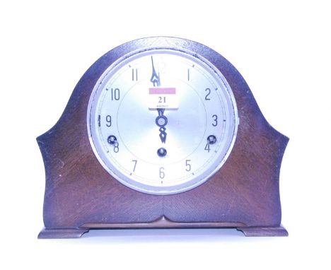 A 1950s oak cased mantel clock having a silvered dial with Arabic numerals and chiming movement, height 21cm