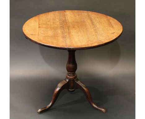 A George III oak tripod occasional table, circular tilting top with 'bird cage' support, baluster pillar, cabriole legs, pad 