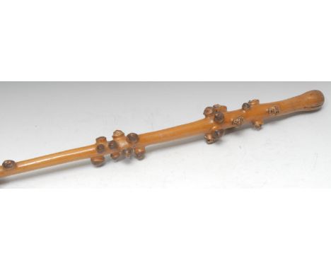 An unusual holly walking stick, the nodules to the top carved with grotesque masks, 89cm long 