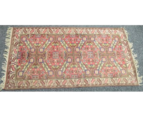 A Middle Eastern woollen carpet, in traditional tones of red, cream, blue and green, with a geometrical patterns, 198cm x 106