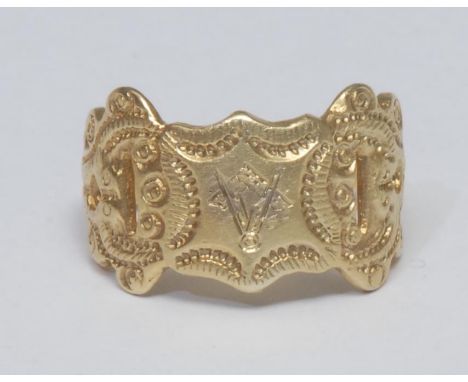 A Masonic signet ring, scrolling cast and pierced crest with embossed Masonic symbol, tapering shoulders, unmarked yellow met