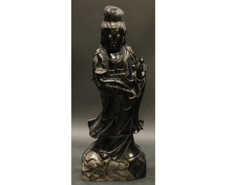 A large Chinese obsidian figure, carved as Guanyin holding a ruyi sceptre and a pearl, 94cm high, 19th/early 20th century