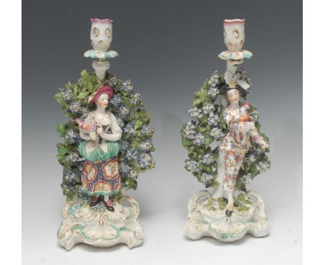 A pair of Derby Patch Mark figural candlesticks, The Italian Farmers, after Meissen originals, he wearing a black hat, floral