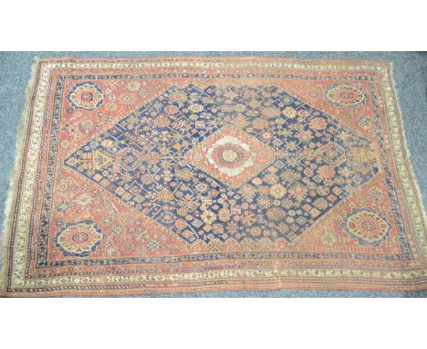 A Middle Eastern woollen carpet, in traditional tones of red and blue, with a geometrical patterns, 227cm x 147cm