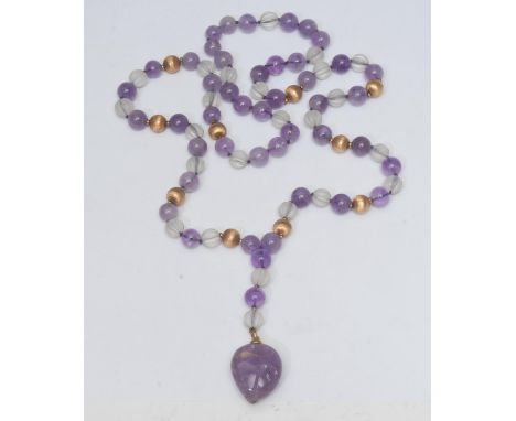 An amethyst, rock crystal and gilt metal bead pendant necklace, amethyst heart drop suspended from uniformly strung necklace 