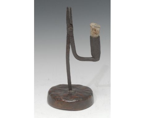 An 18th century wrought iron nip rush light holder, the arm with candlestick socket, softwood base, 23.5cm high