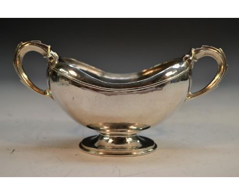 Omar Ramsden - an Arts and Crafts silver boat shaped pedestal sugar basin, domed foot, scroll handle, 16cm wide, London 1931,