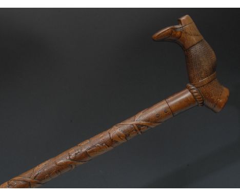 A late 19th/early 20th century century Folk Art walking stick, the handle carved as a leg wearing a boot, the haft carved wit