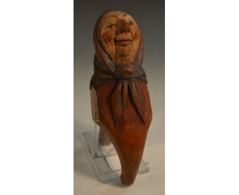 A Black Forest lever action novelty nut cracker, carved and polychrome painted as a Tyrolean peasant woman, 18cm long, c.1900