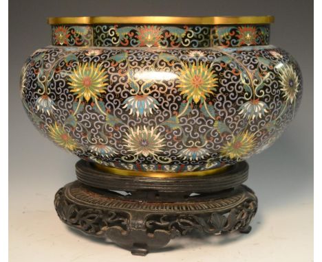 A Chinese cloisonné lobed ovoid jardiniere, profusely decorated in polychrome with lotus, flowers and scrolls on a deep blue 