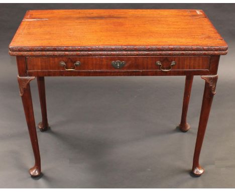 A 'George II' mahogany concertina action card table, folding top with carved edge enclosing an inset baize lined playing surf