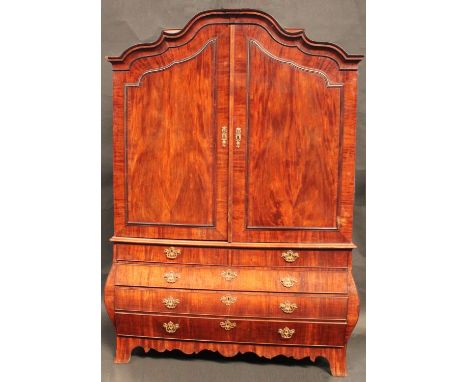 A large 19th century Dutch mahogany bombe shaped linen press, shaped arched cresting above a pair of doors, the base with two