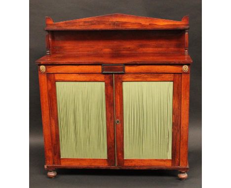 A George IV gilt metal mounted rosewood library pier cabinet, pointed arched superstructure, with rounded rectangular shelf, 