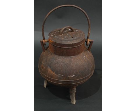 A 19th century cast iron tripod cauldron and cover, swing handle, outswept legs, 43cm high