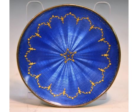An early 20th century silver and enamel circular miniature dish, applied in gilt on a blue guilloche ground, 5cm diam, early 